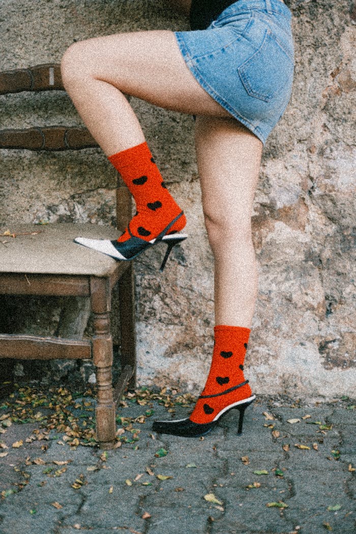 Woman wearing red heart socks with high heels outdoors.