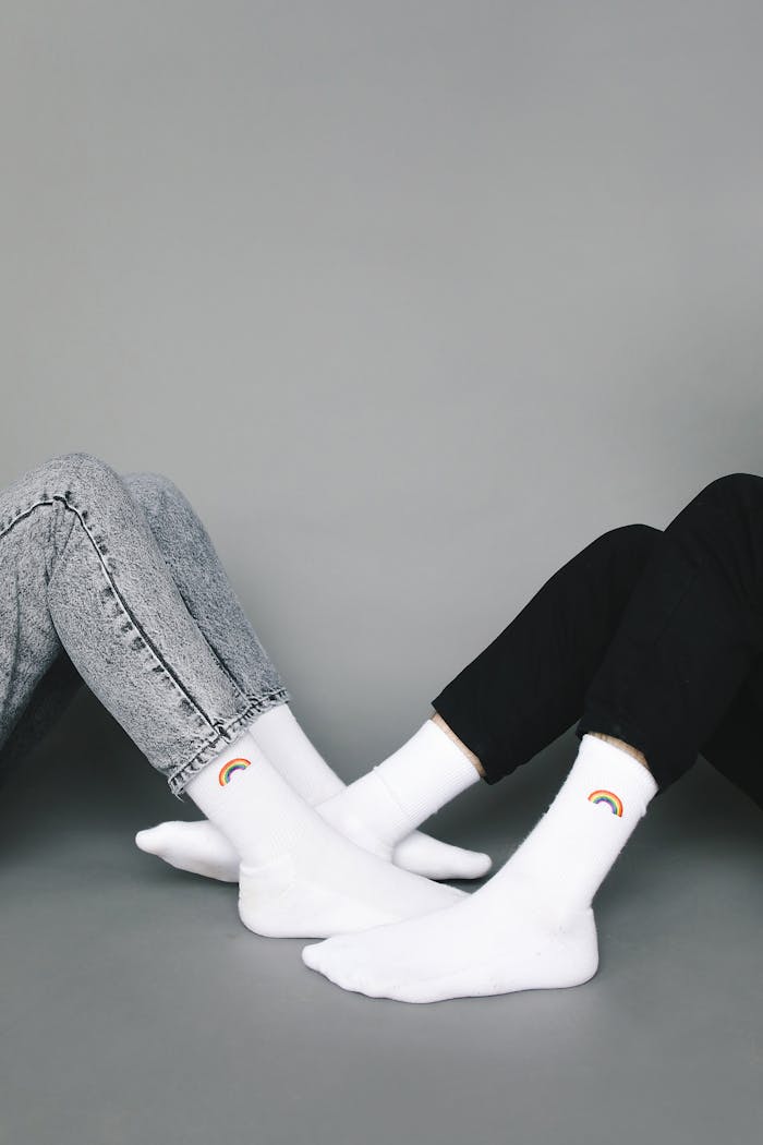 Studio photo of two people wearing rainbow socks, showcasing simple yet stylish fashion.